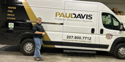 Water damage restoration technician standing beside emergency service van for water damage restoration in Berwick ME